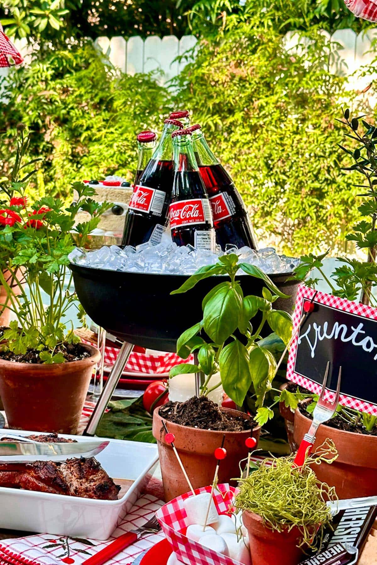 COKE BOTTLES SIT IN A SMALL BBQ WITH DRIED ICE AS THE THEME FOR THE PARTY IS SMOKING BBQ.