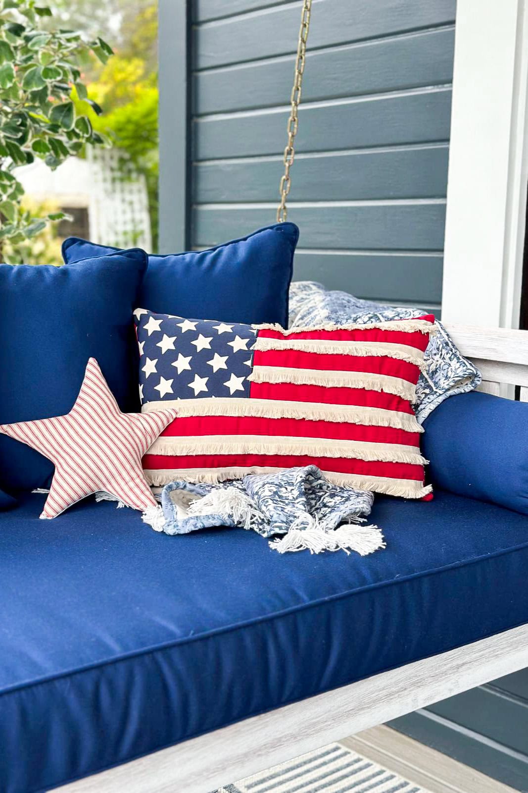 Decorating with American Flag pillows on a front porch swing