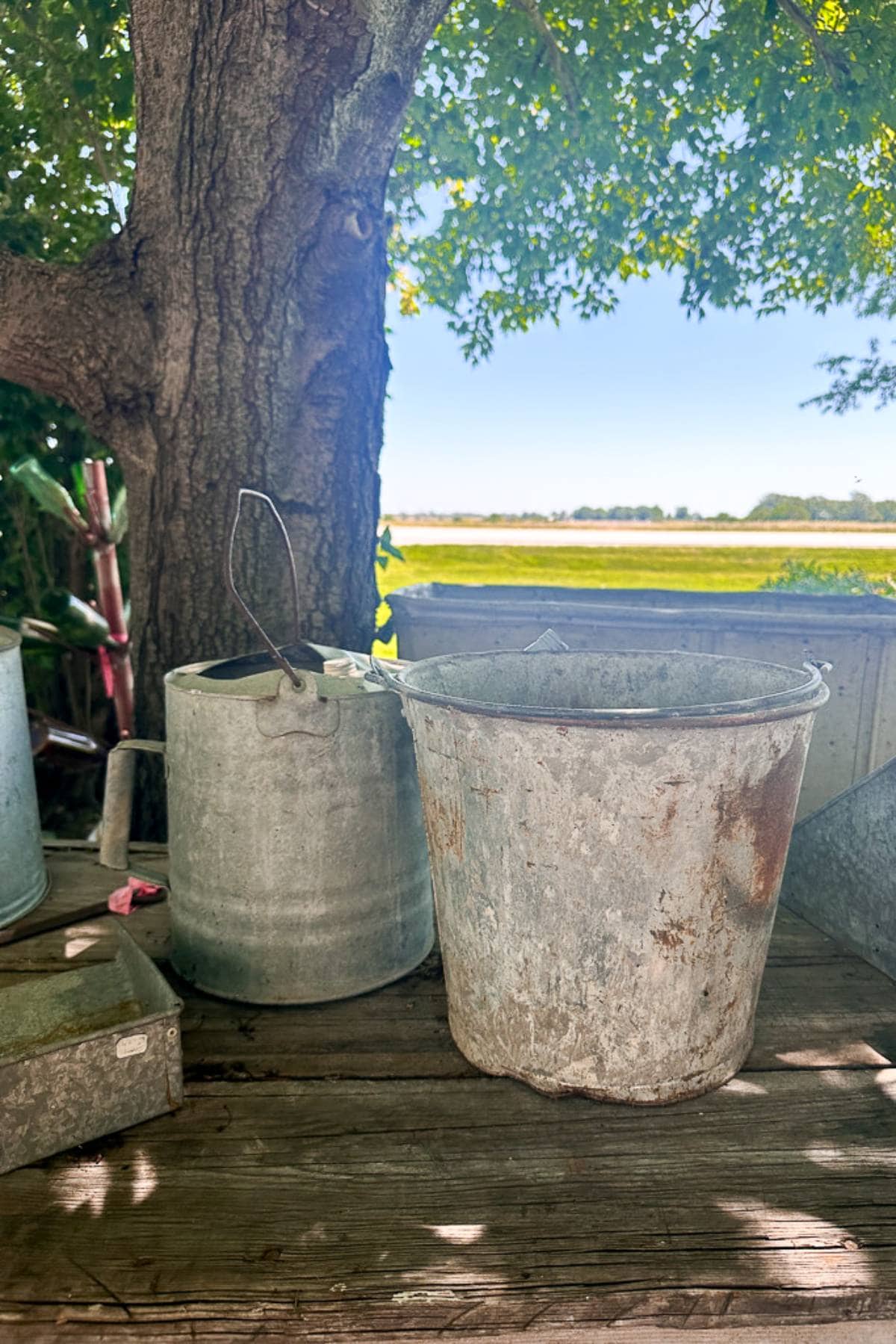 Vintage metal buckets at an open flea market.