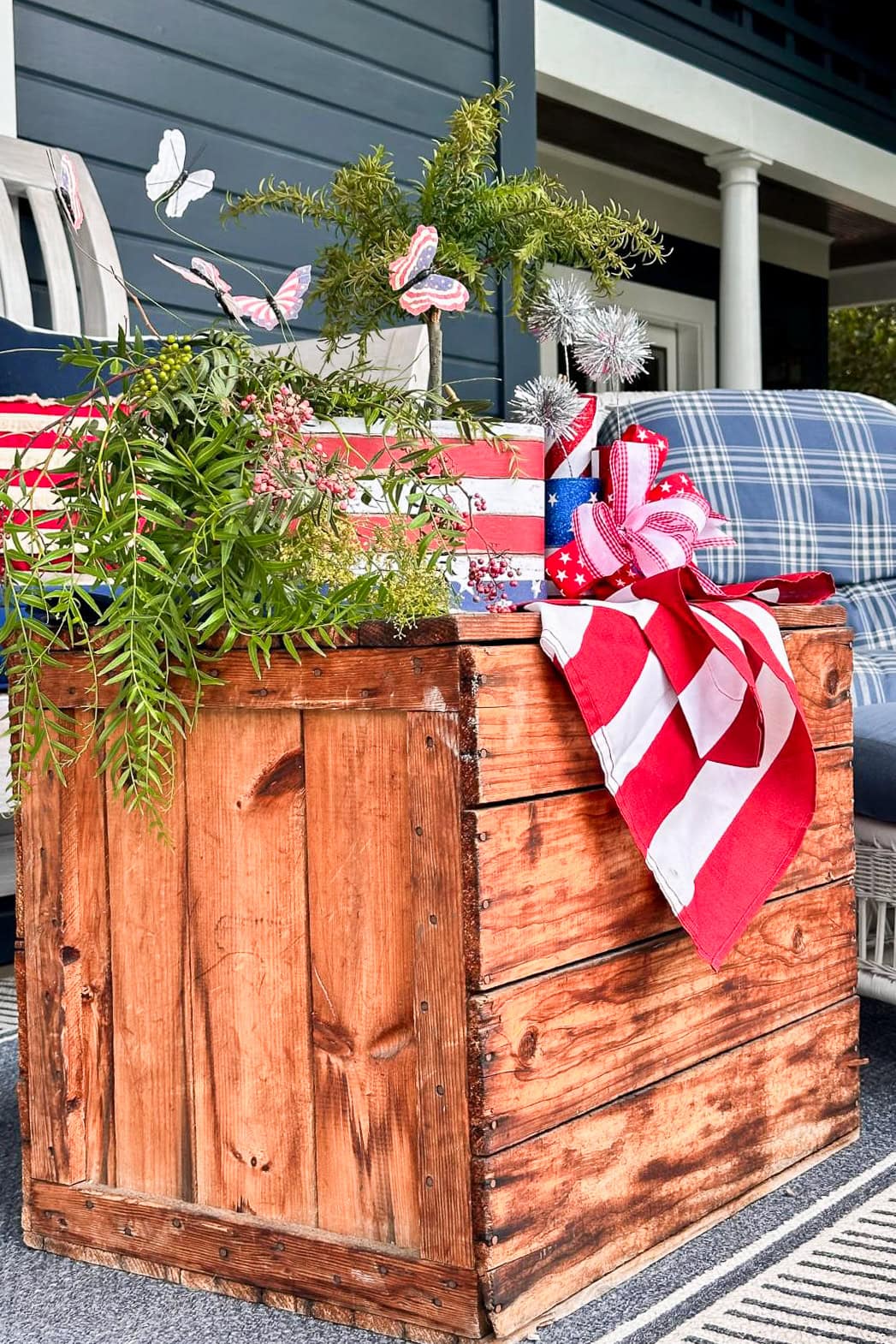 front porch side table decorated with patriotic red, white, and blue decorations and summer flowers