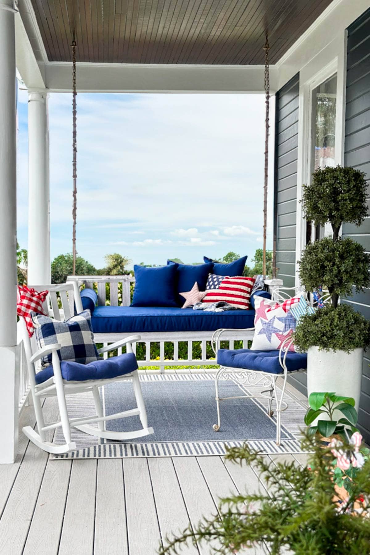 An All-american front porch decorated for the fourth of July with a porch swing. 