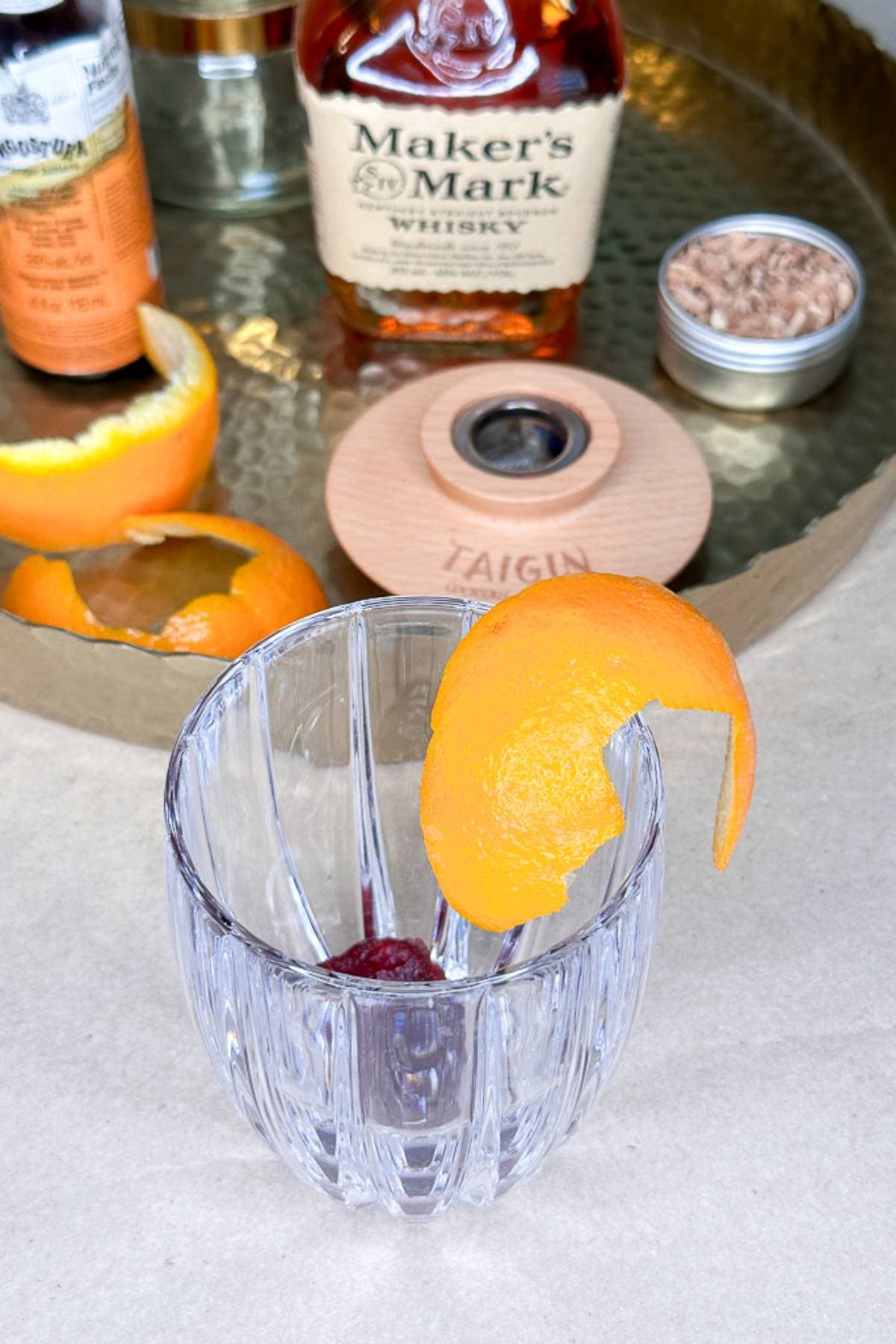 Rubbing the rim of a glass with orange peel for an old fashioned cocktail