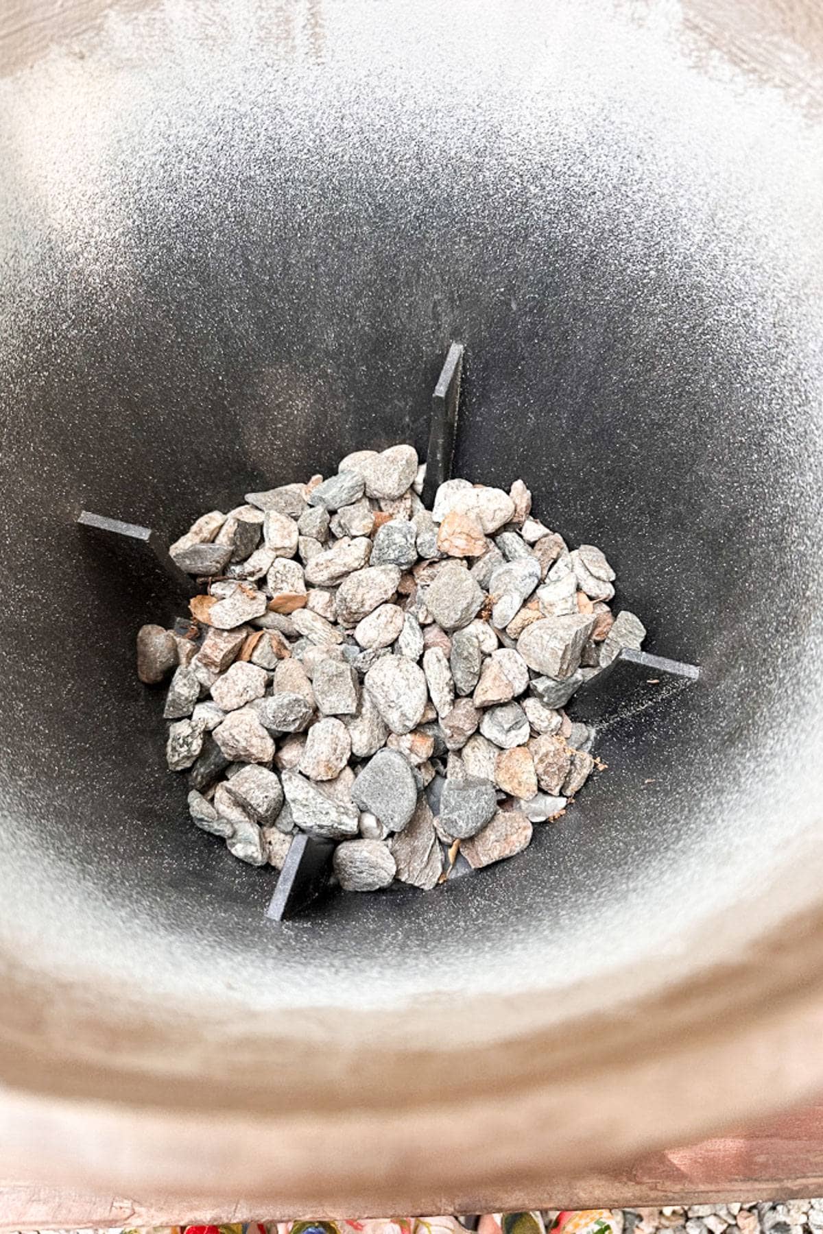 Flower pot with rocks placed in the bottom for drainage. 