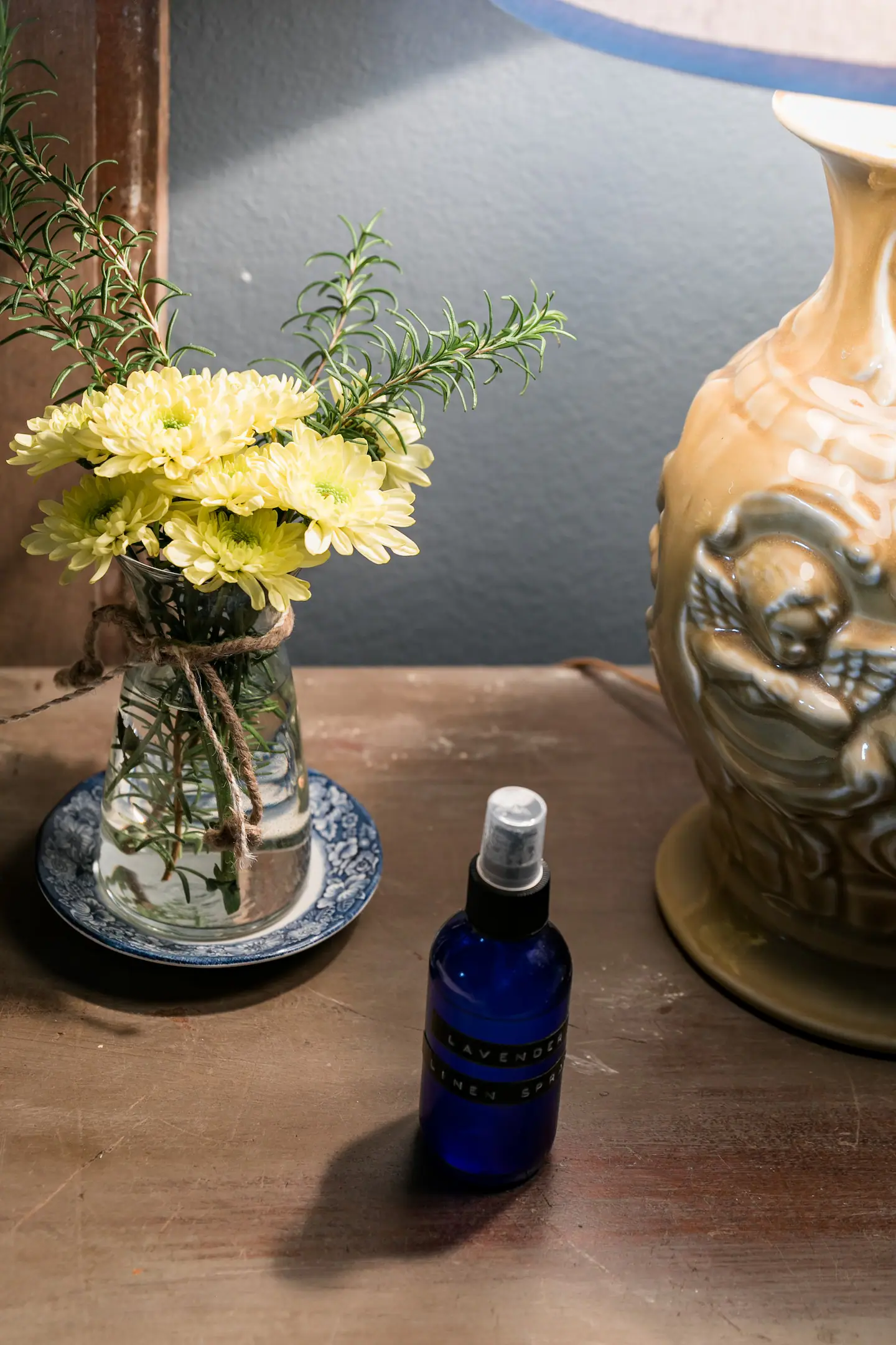 Bouquet of fresh yellow flowers and antique lamp on a beside table in Texas airbnb