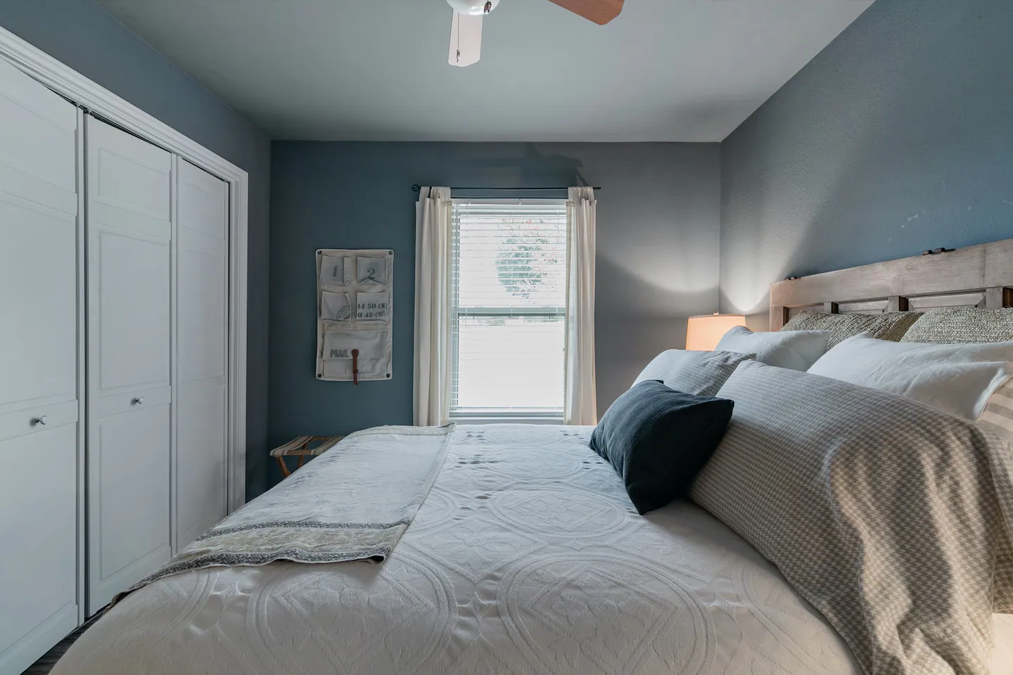 View of window and bedding in blue bedroom 