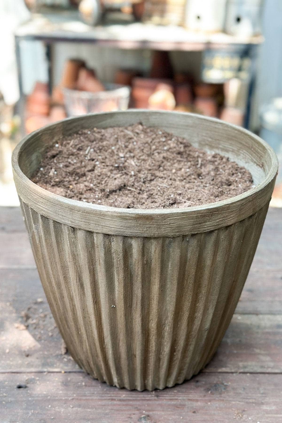 A flower pot with potting soil ready for planting.