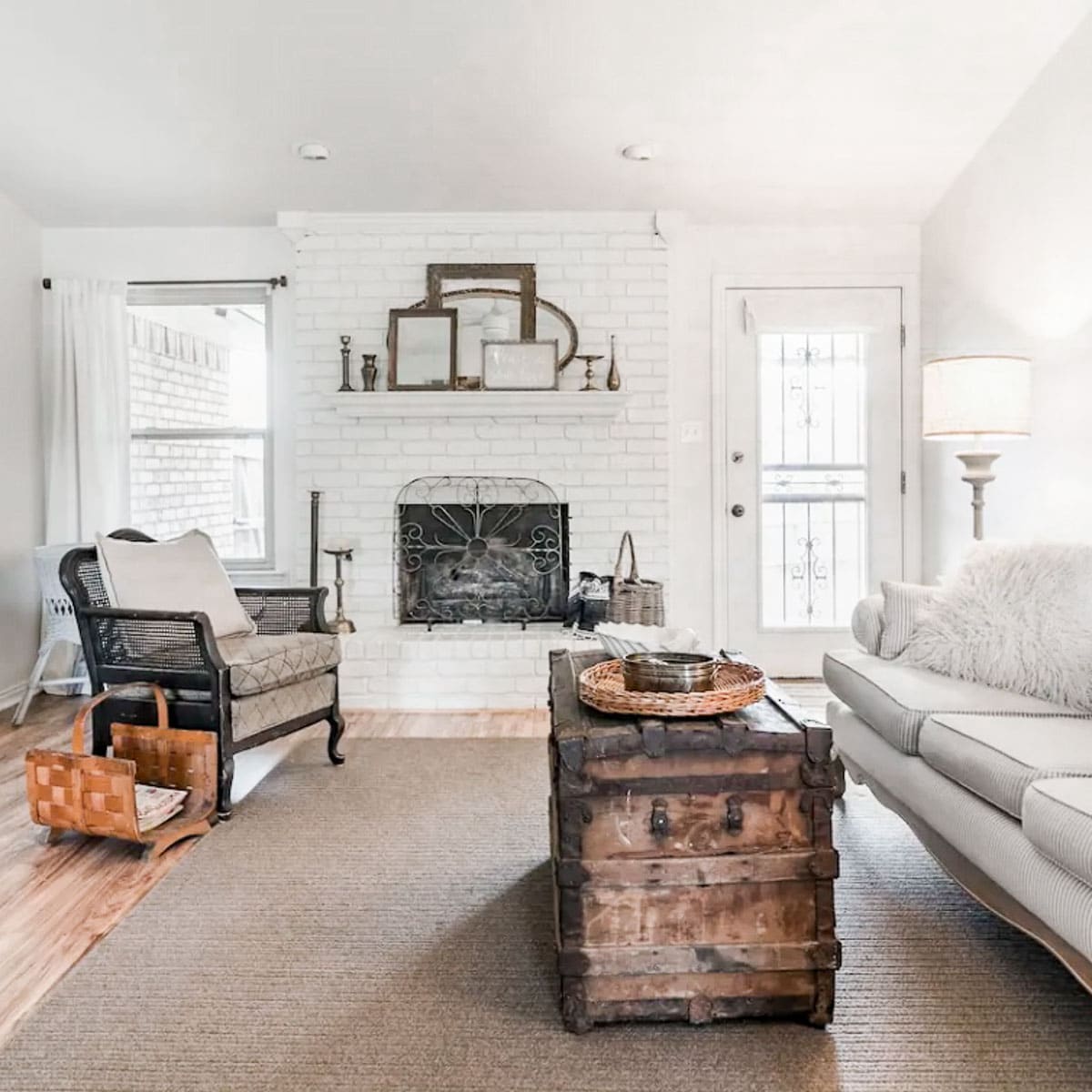 a living room of an Airbnb with a soft white couch and a trunk for an coffee table. 