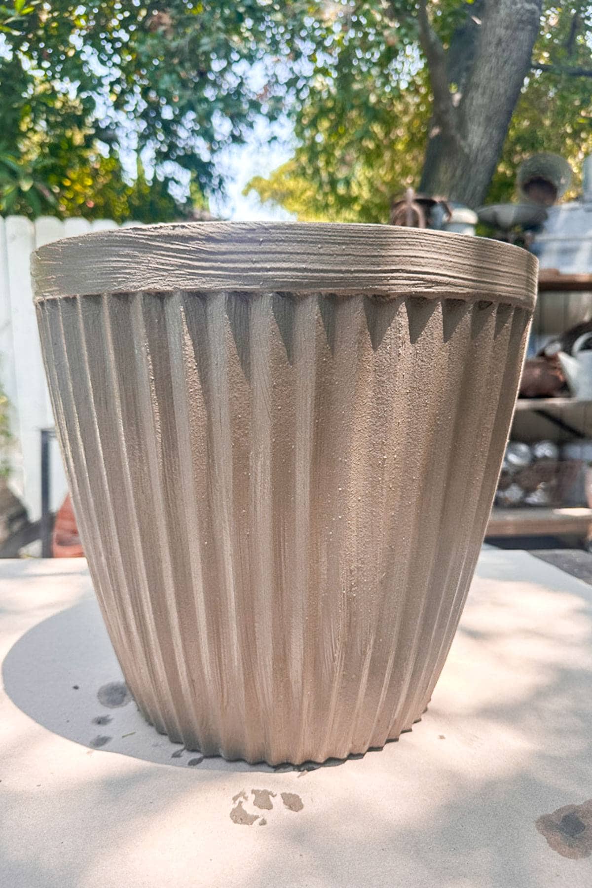 A plastic flower pot with a cement coating was applied. 