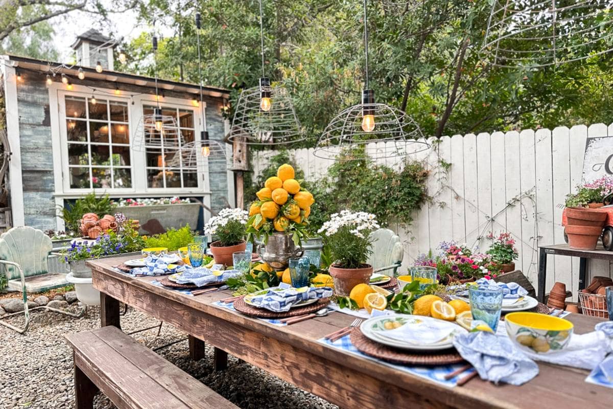 Outdoor summer tablescape with lemons set in the backyard garden near the she shed