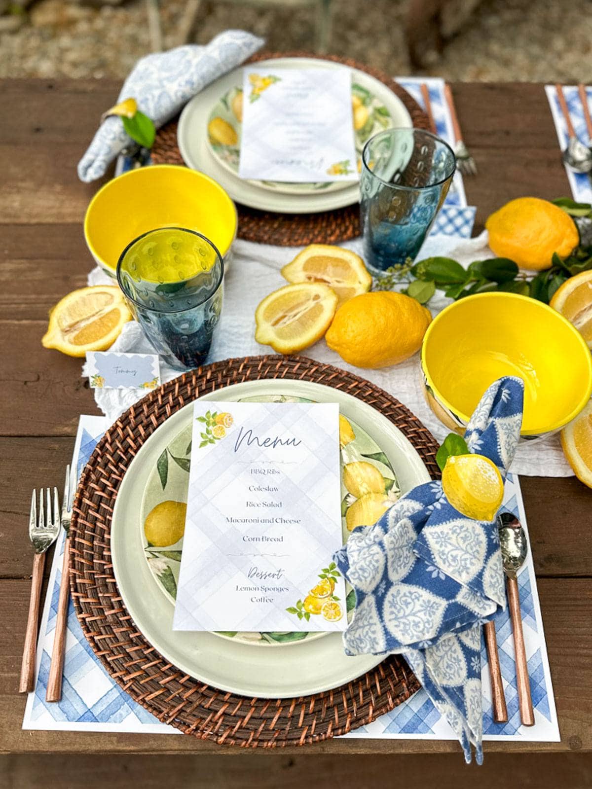 A place setting with rattan chargers for a summer tablescape with a lemon theme.