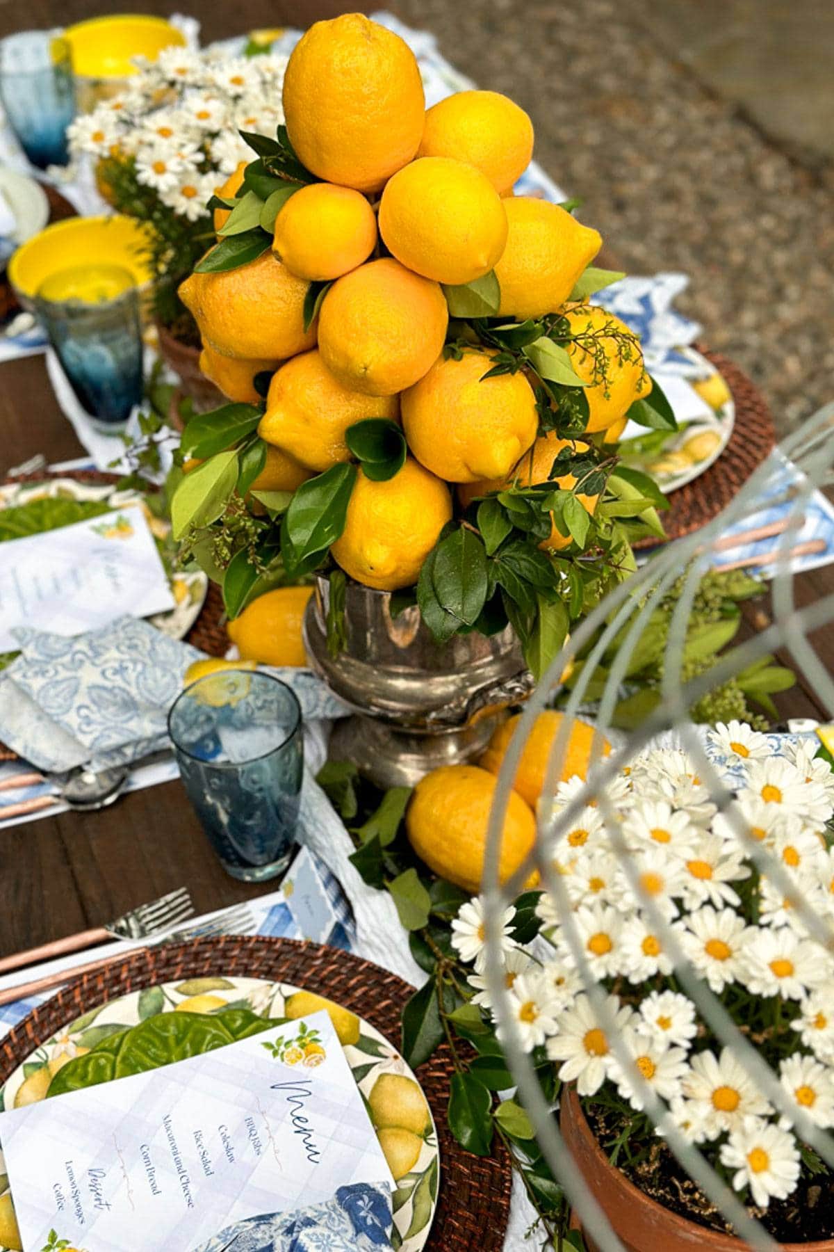 DIY centerpiece made with fresh lemons and greenery in a vintage silver urn on a summer tablescape