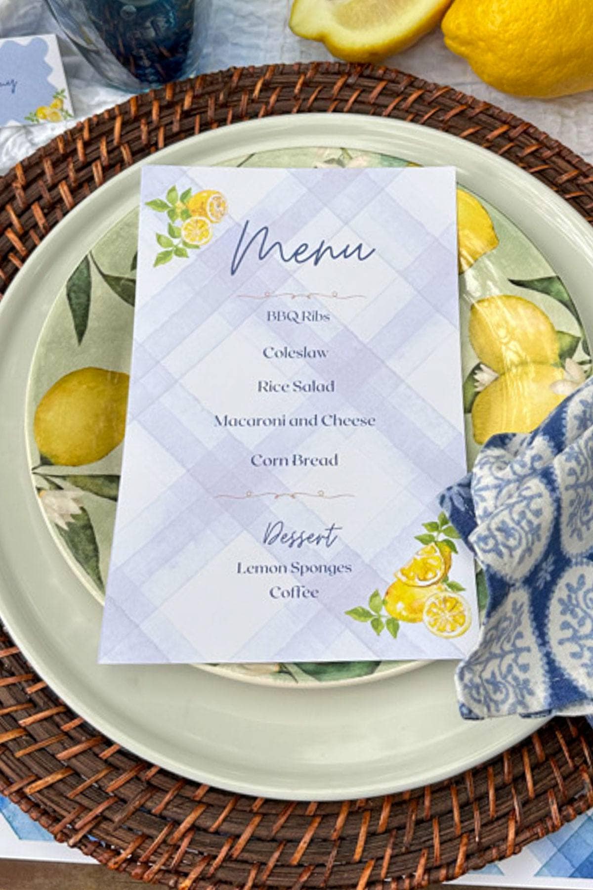 A place setting with rattan chargers for a summer tablescape with lemons and a free printable party menu