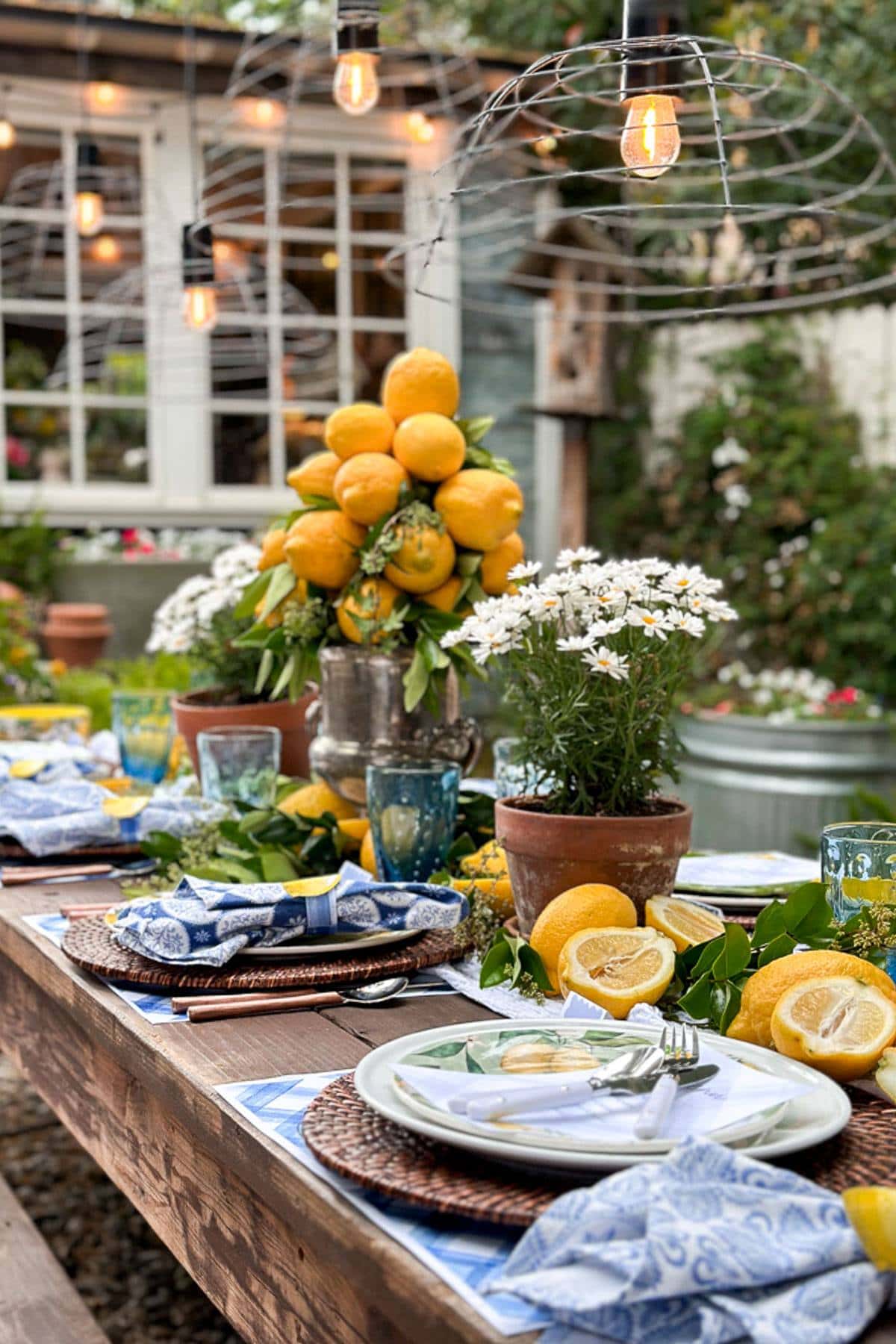 A Summer tablescape full of fresh lemons and a lemon centerpiece. This table also features beautiful blue and white napkins, placemats and other free printables for you to create your own table just like this one.