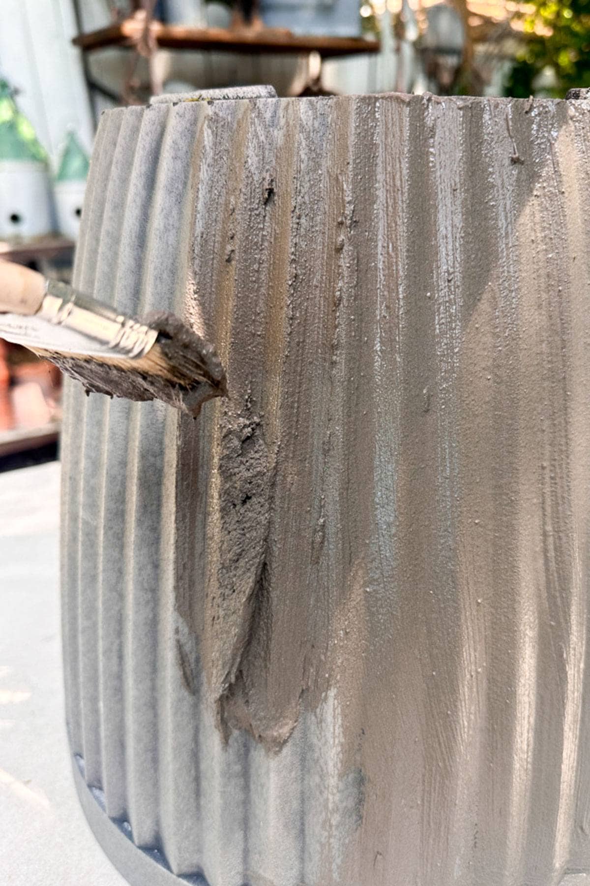 I am painting the concrete onto the flower pot with a chip brush. 