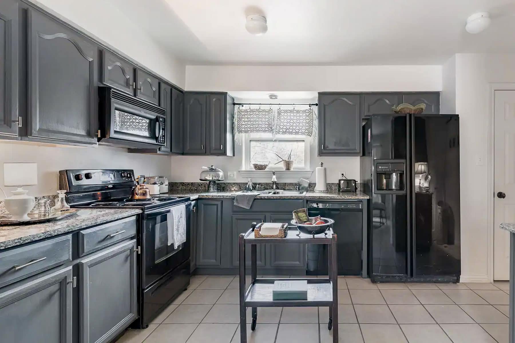 Kitchen with grey cabinets of an Airbnb in Dallas, Texas.