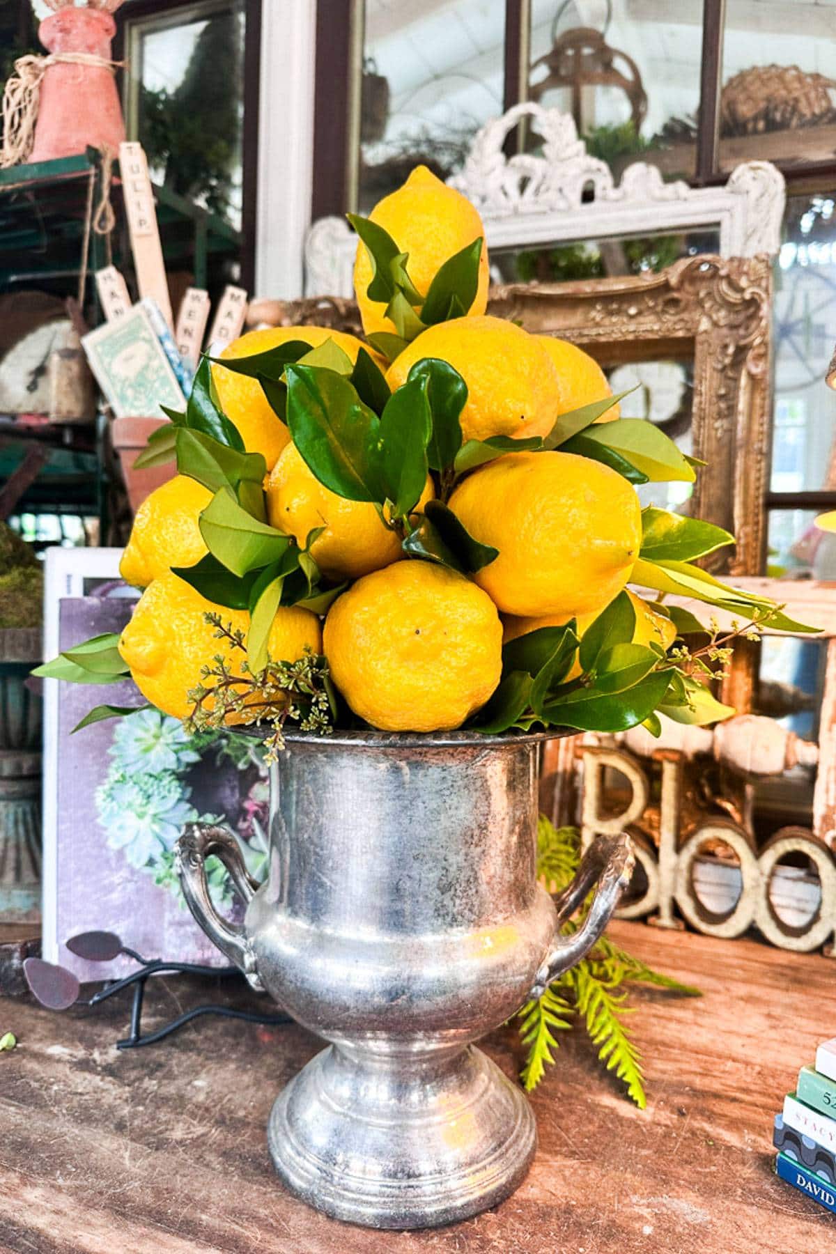 A fresh lemon tree with fresh greenery in a vintage silver ice bucket creates a beautiful lemon centerpiece. 