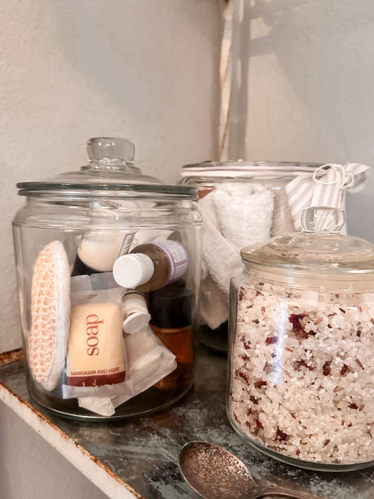 Jar on the bathroom filled with small toiletries. 