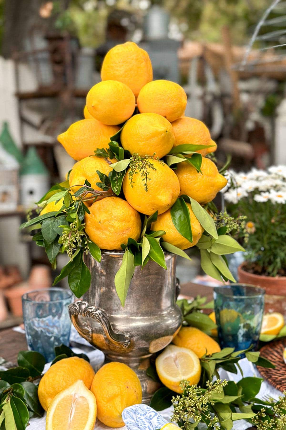 Lemons are stacked on a vintage silver ice bucket to create a lemon centerpiece. 