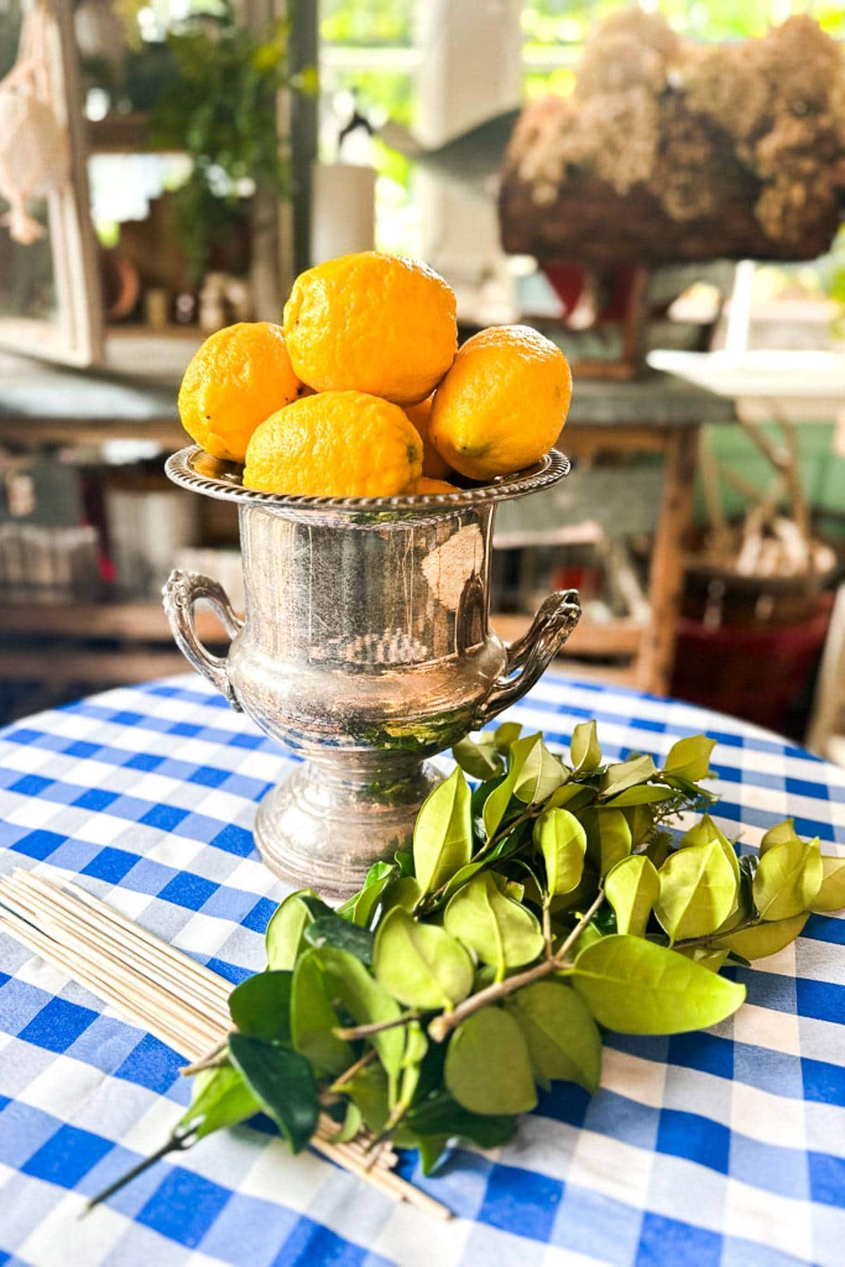 A vintage silver ice bucket will be used as the vase for a lemon centerpiece. 