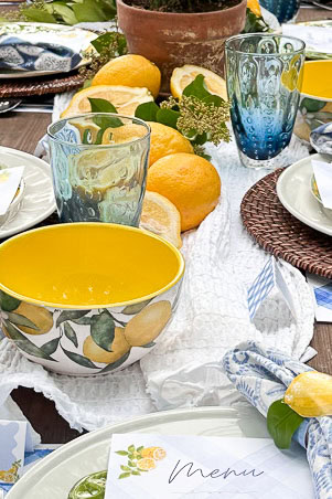 A white puckered runner is placed as a base on a summer tablescape with lemons.