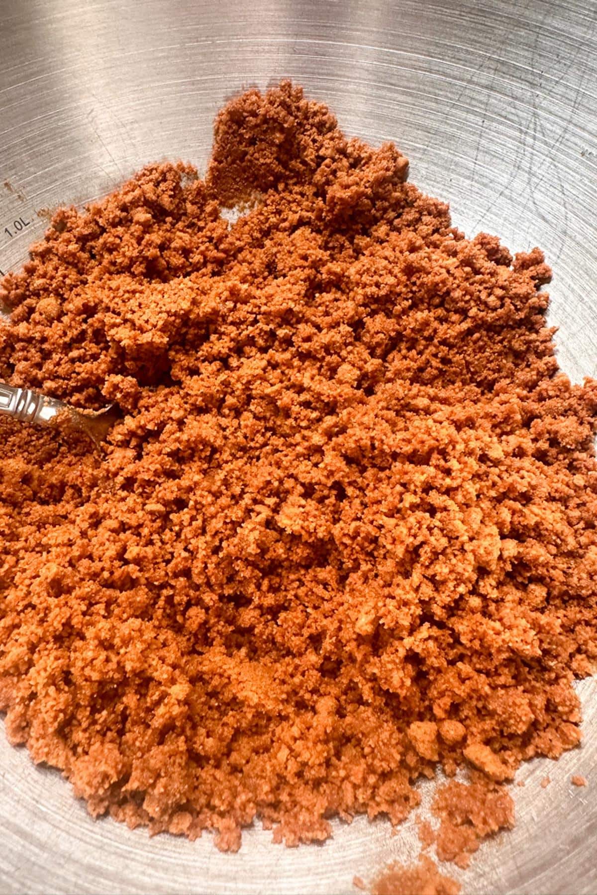 A close up of crushed Biscoff cookies preparing to make a crust for no bake pumpkin cheesecake bars.