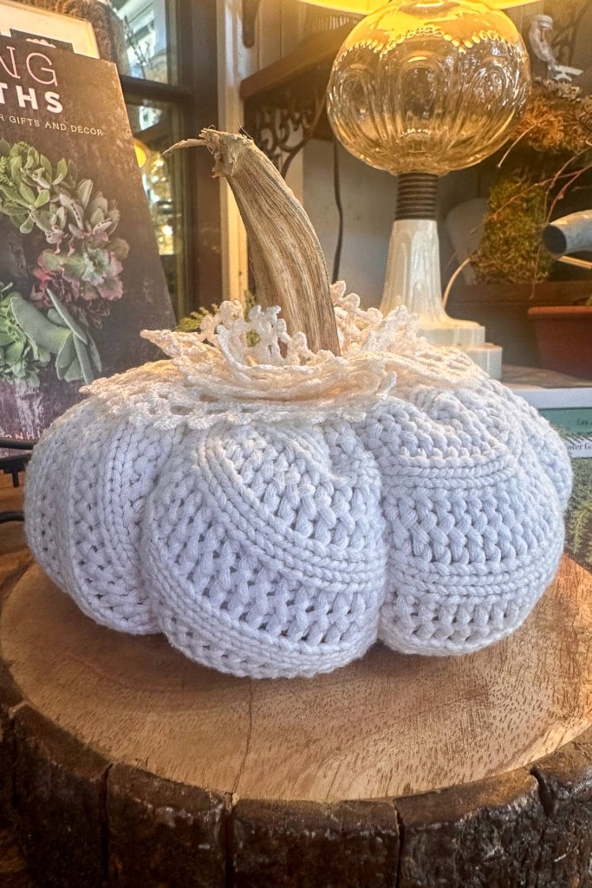 A sweater pumpkin with a lace doil decorating the top and a real pumpkin stem hot glued to the top. 