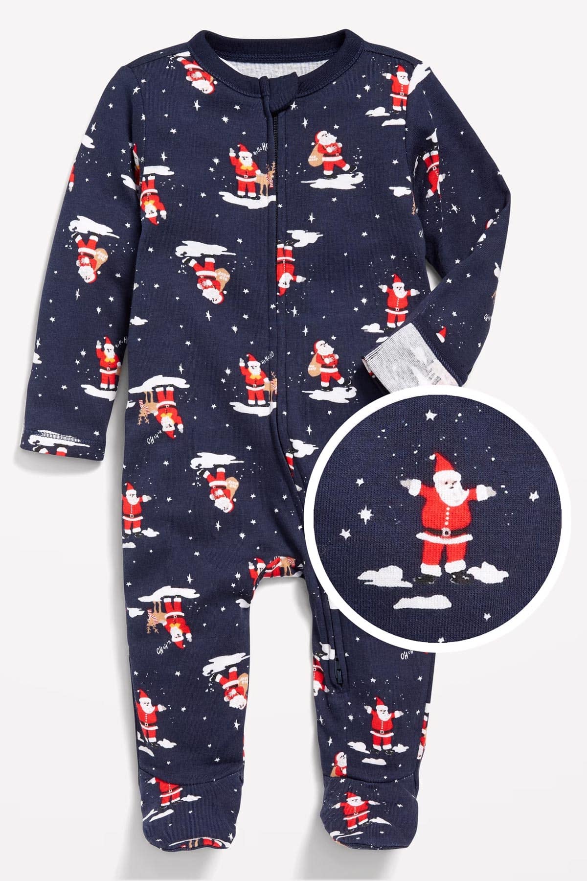 A navy blue baby onesie with Santa Claus and snowflake patterns. The suit has long sleeves and a zipper down the front. A close-up shows a Santa figure standing on a cloud, wearing a red suit.