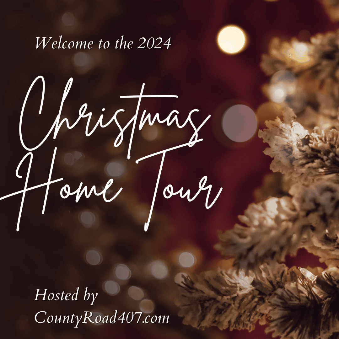 Festive image with a Christmas tree adorned with blue and white Christmas decor, lights, and ornaments. Text reads, "Welcome to the 2024 Christmas Home Tour" and "Hosted by CountyRoad407.com" in elegant script. Warm, cozy ambiance with blurred lights in the background.