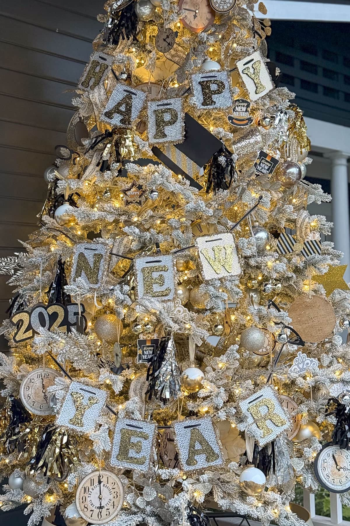 A festive Christmas tree adorned with silver and gold ornaments, illuminated lights, and decorations reading "Happy New Year" and "2023." The tree features clocks and sparkly accents, creating a celebratory atmosphere.