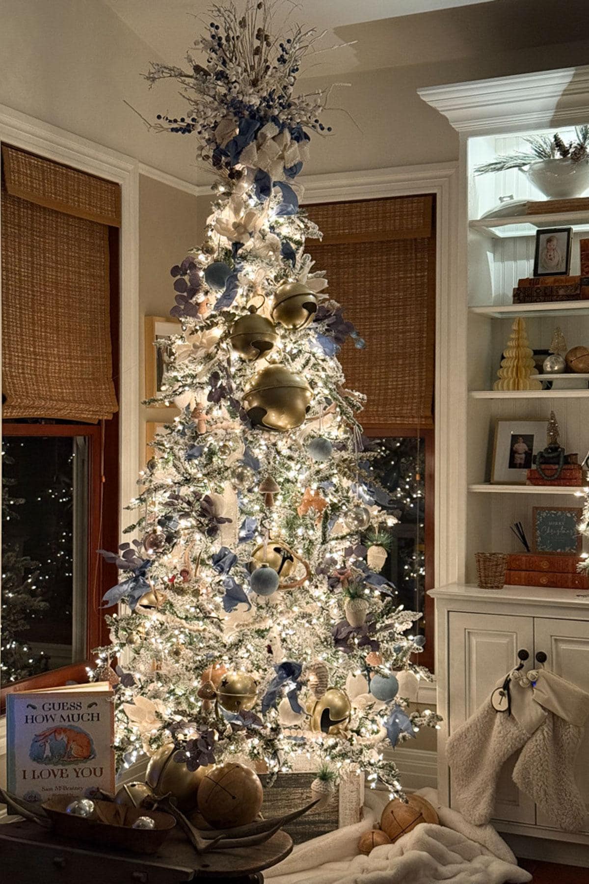 A beautifully decorated Christmas tree, embodying classic Christmas decor with golden and blue ornaments, white lights, and a silver tree topper. The tree is surrounded by cozy decorations and gifts, all bathed in warm ambient lighting that enhances the nostalgic holiday atmosphere.