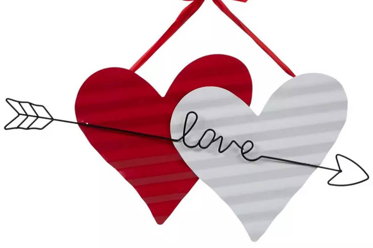 Two hearts, one red and one white, with a black arrow piercing through them. The word "love" is incorporated into the arrow's design. A red ribbon is used for hanging the decoration.