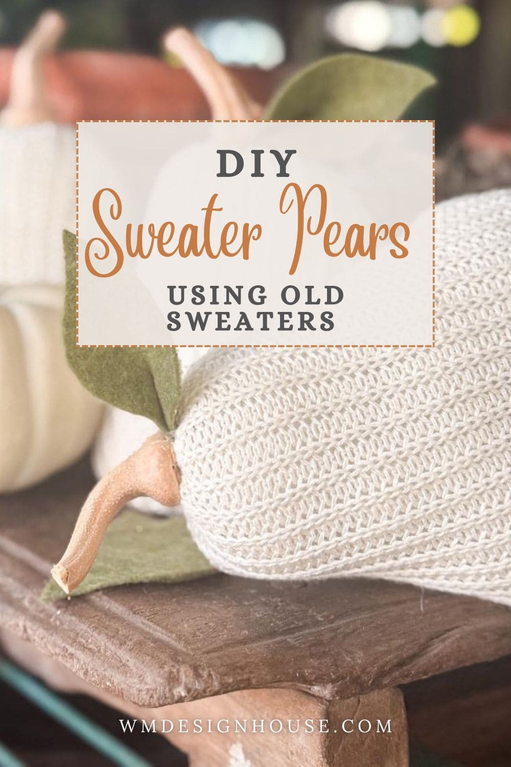 DIY Sweater Pears-A close-up of DIY Sweater Pears crafted from cream-colored knitted sweaters with felt leaves, resting on a wooden table. Text overlay reads "DIY Sweater Pears Using Old Sweaters." Website wmddesignhouse.com at the bottom.