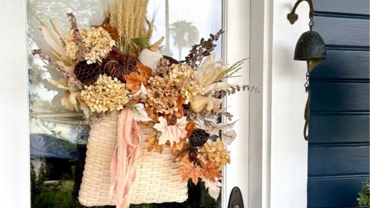 A thrifted fall door basket filled with flowers and plants adds a charming touch to any entryway.