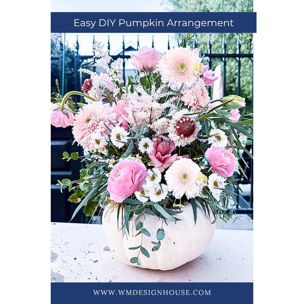 A White Pumpkin Flower Arrangement featuring pink and white blooms with greenery is displayed in a white pumpkin vase. The text above reads "Easy DIY Pumpkin Arrangement," with "www.wmdesignhouse.com" shown below.
