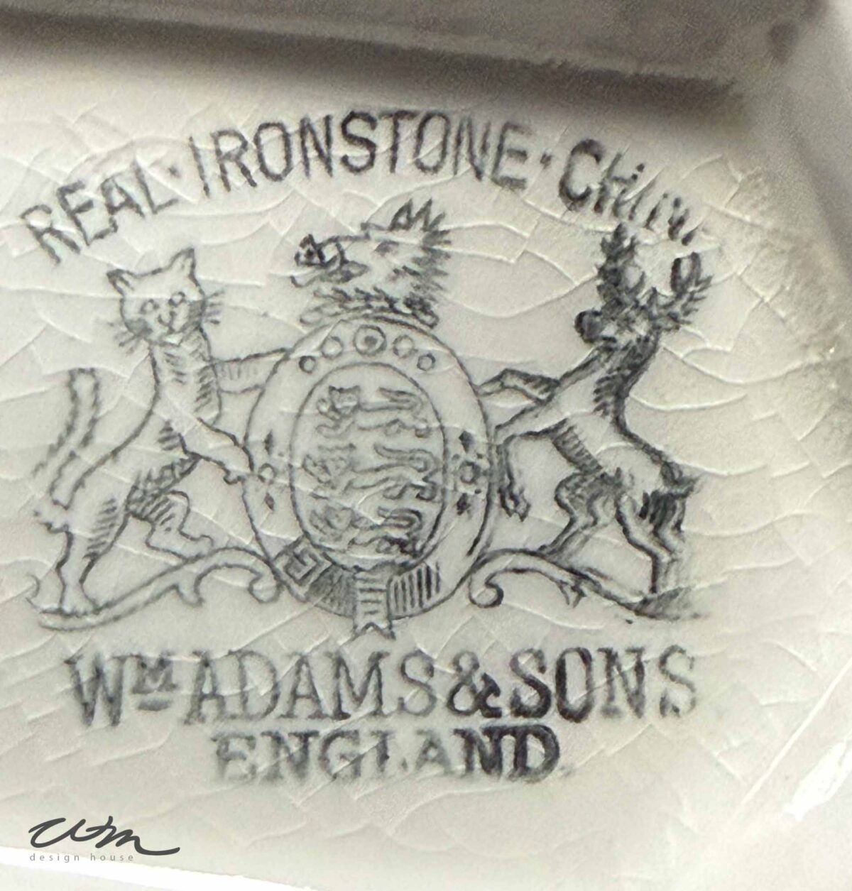 Black ink stamp on cracked Vintage White Ironstone ceramic reads: "REAL IRONSTONE CHINA, W. ADAMS & SONS, ENGLAND" with a lion, shield, and unicorn crest. The signature “WDM design+house” is at the bottom left.