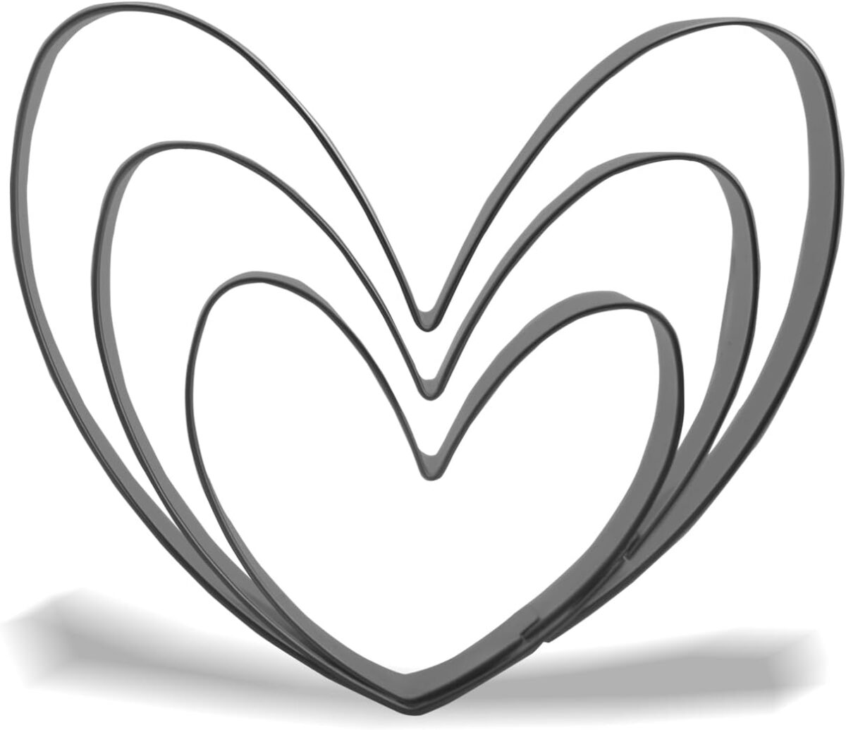 Three nested heart-shaped cookie cutters of increasing size, made of metal, are arranged upright. Perfect for making Heart Sugar Cookies, they cast soft shadows on a white background.