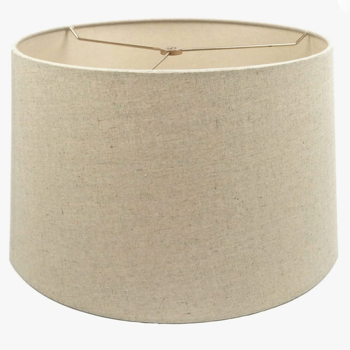A plain, cylindrical beige lampshade with a slightly wider base and a metal frame across the top opening—perfect if you want to line a lampshade with leftover wallpaper for an easy, stylish update.