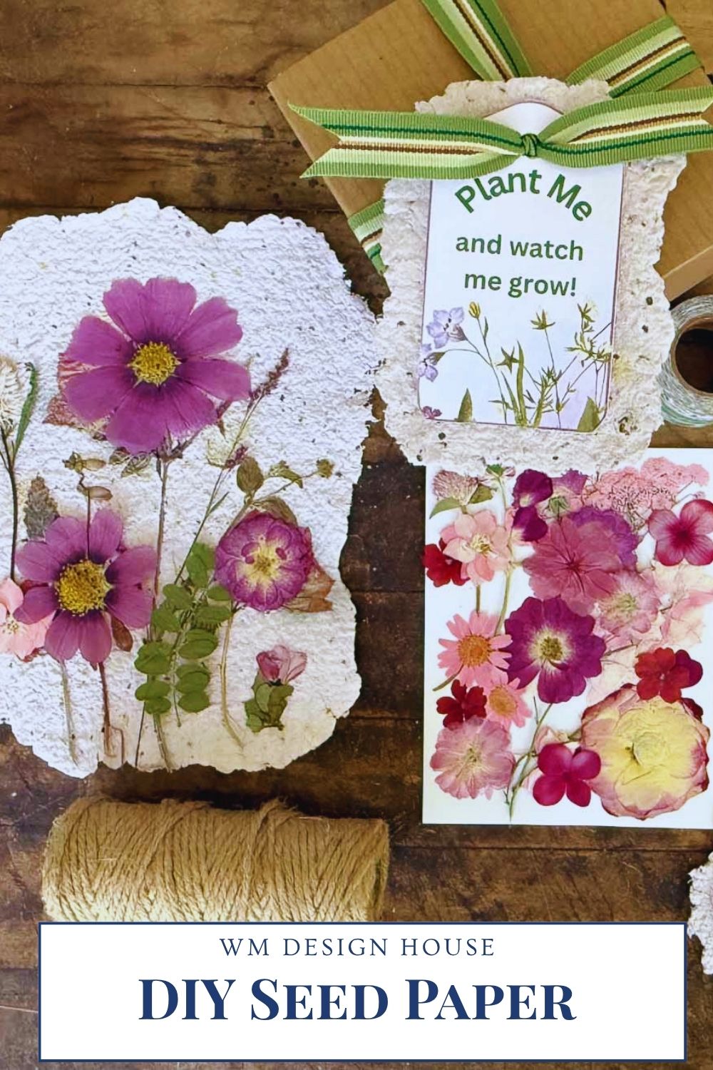 Handmade seed paper decorated with pressed pink and purple flowers lies on a table with twine, floral cutouts, and a “Plant Me and watch me grow!” tag attached to a gift box—perfect for DIY seed paper handmade cards or unique stationery.