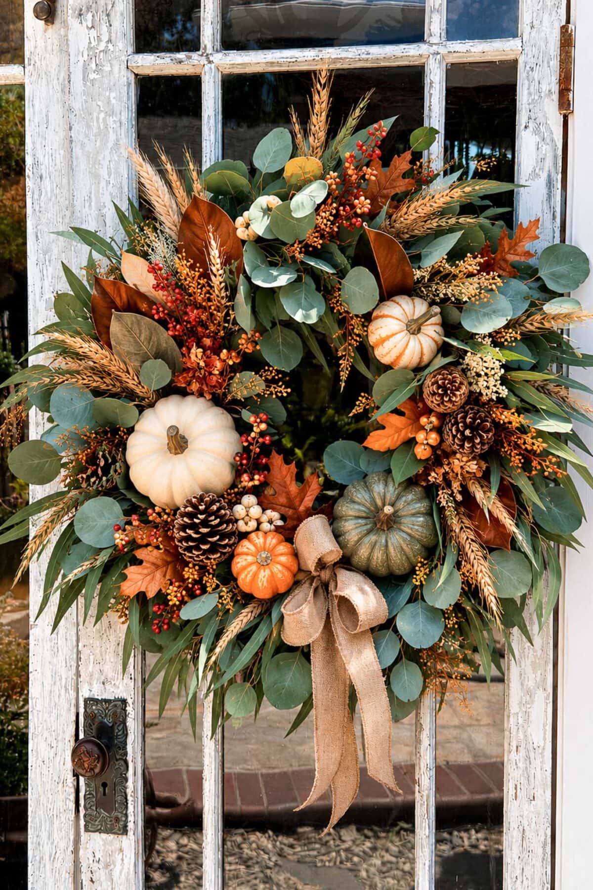 Autumn harvest wreath featuring pumpkins, pinecones, and fall foliage for seasonal home decoration.