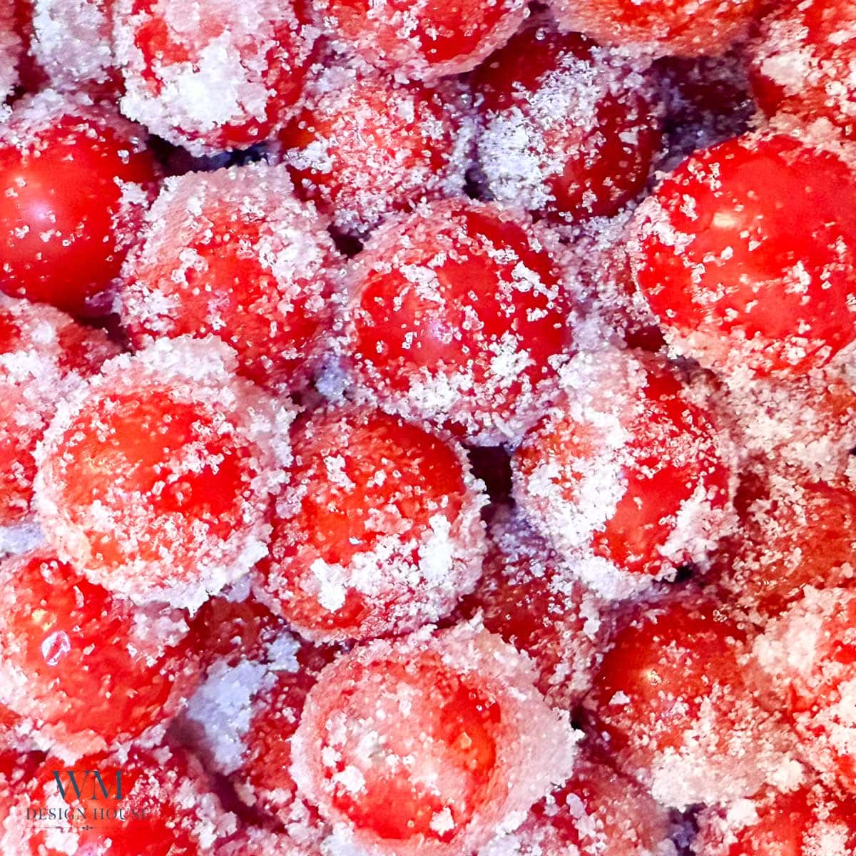Close-up of bright red cherries coated in granulated sugar, creating a frosty and sparkling effect on the fruit’s surface.