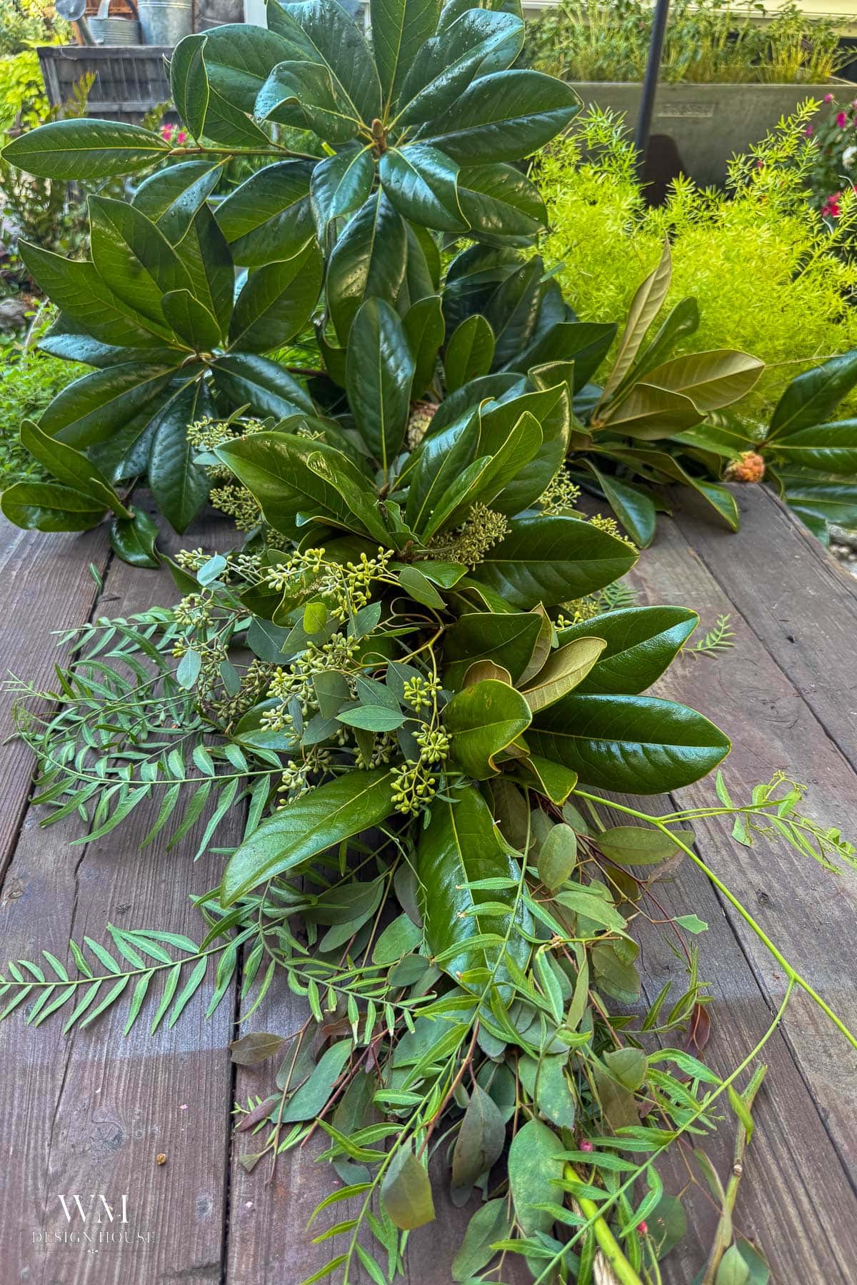 Building a greenery table runner with magnolia, seeded eucalyptus, and pepper berry