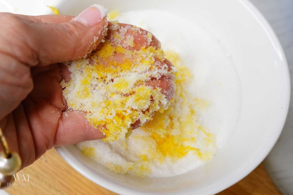 Sour cream being poured into creamed butter and lemon sugar in a stand mixer bowl