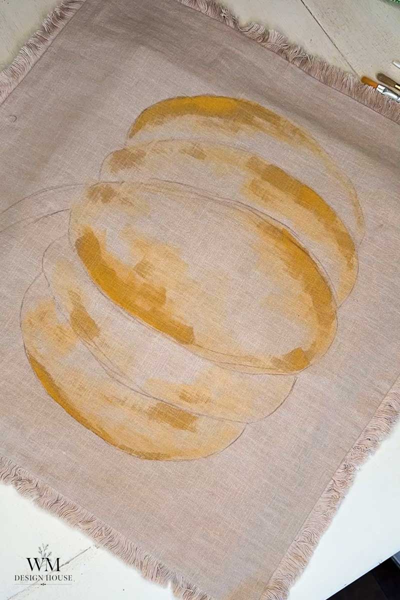 A painted image of a stack of golden-brown bread slices on a light beige cloth with frayed edges, placed on a white surface. Brushes are partially visible in the top right corner.