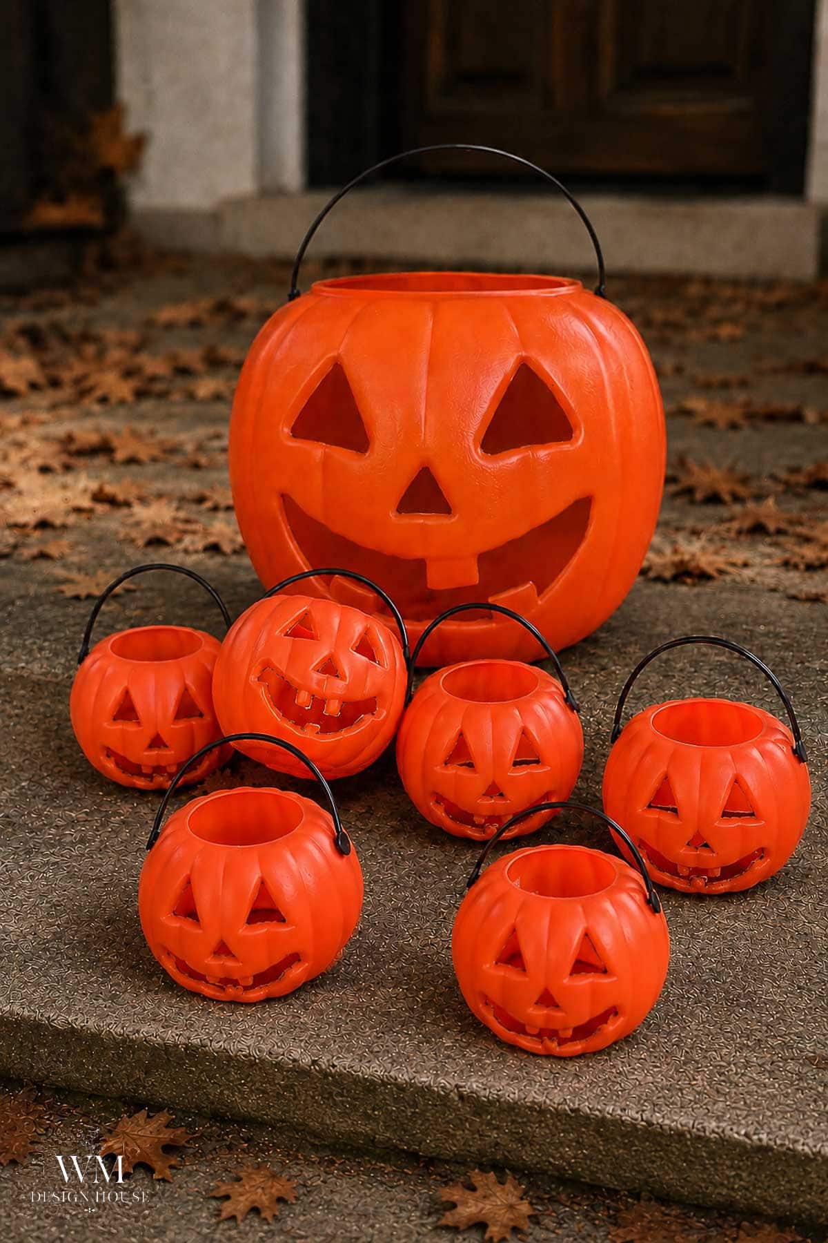 Orange plastic pumpkin trick or treat buckets lined up on a porch before painting