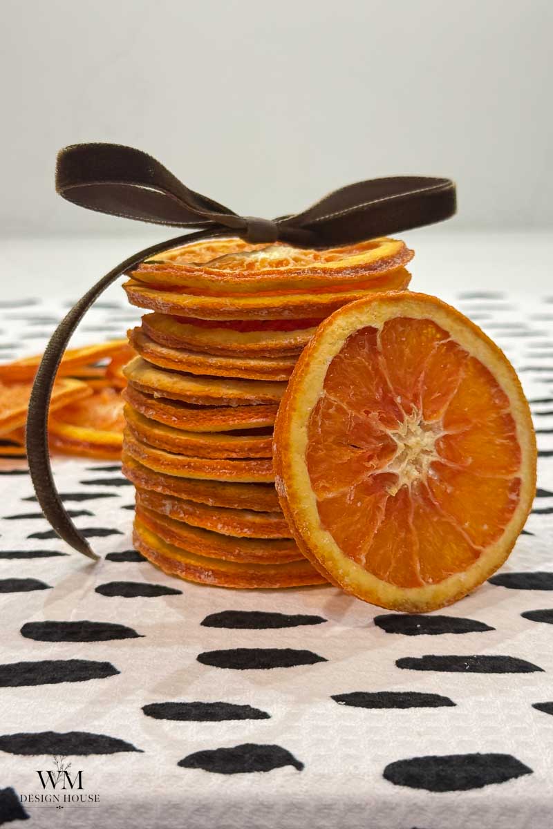 A stack of dried orange slices tied together with a brown ribbon.