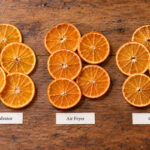 Three groups of dried orange slices arranged on a wooden surface, labeled below as Dehydrator, Air Fryer, and Oven to show how to dry oranges.